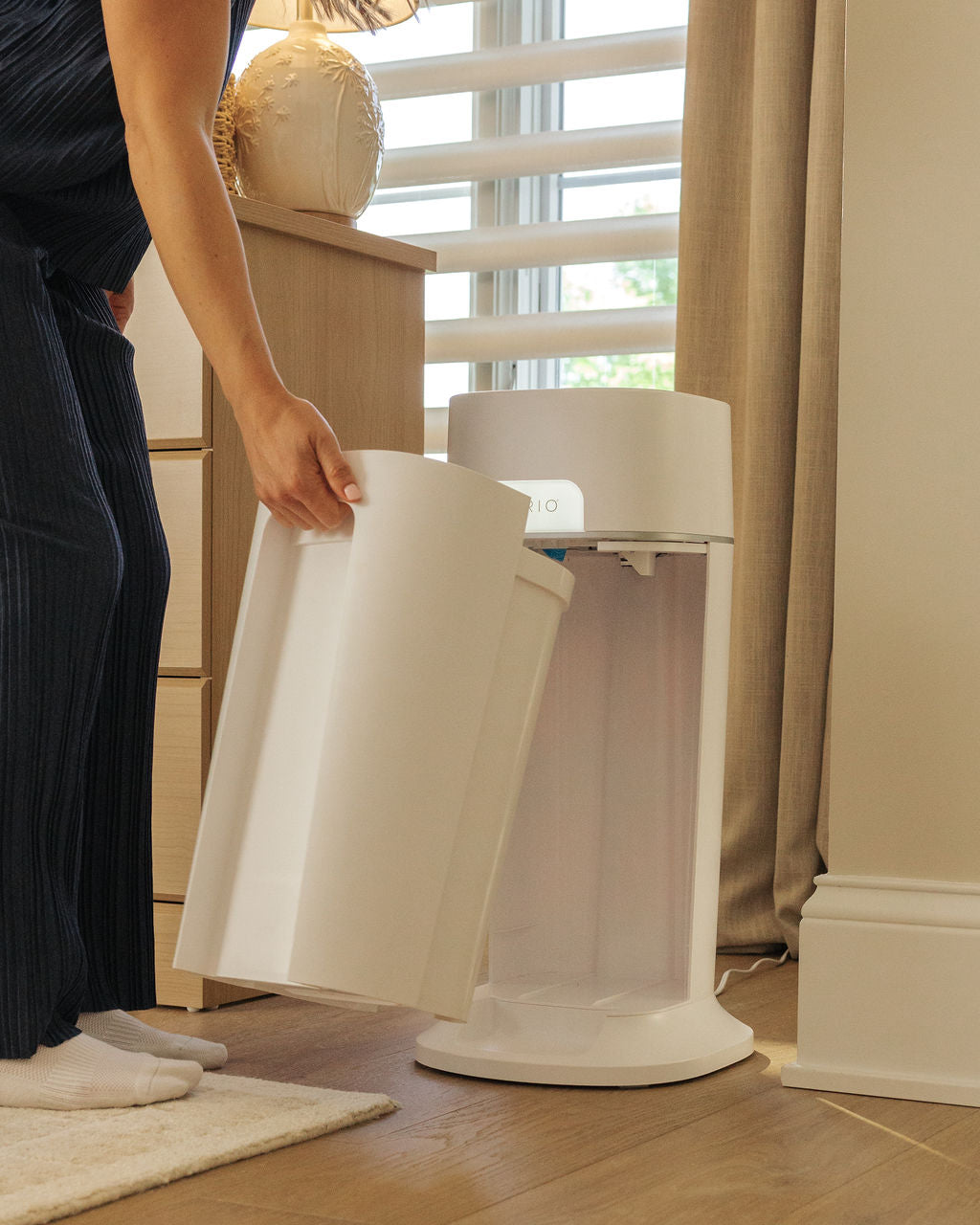 Mother removes dirty diaper compartment easily from the diapersealer pail.