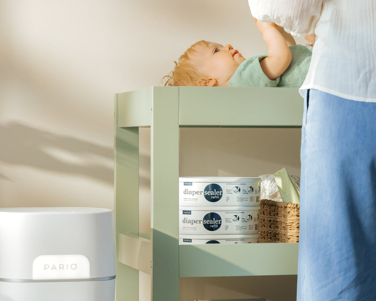 Baby on a changing table with DiaperSealer products in the background.