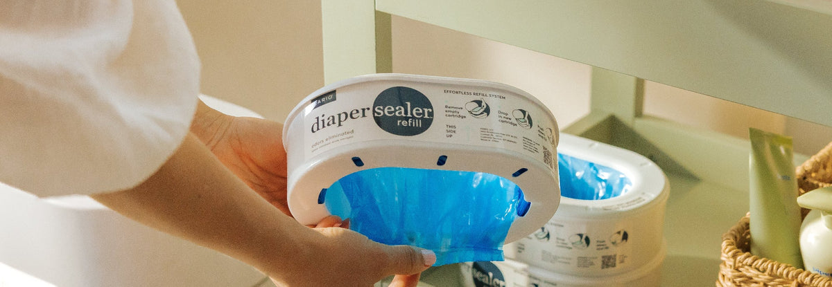 Person using a diaper sealer refill kit on a shelf.